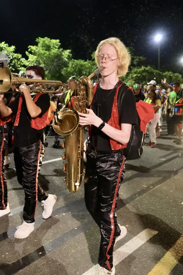 Músico tocando el saxofón en el desfile de noche